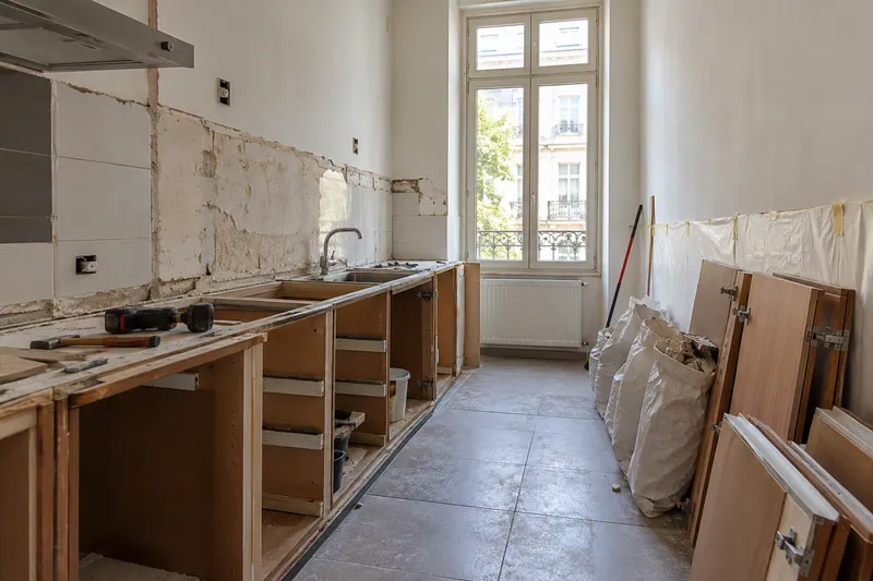 Visualización conceptual IA: Retirada de muebles y revestimientos al comienzo de una reforma de cocina.